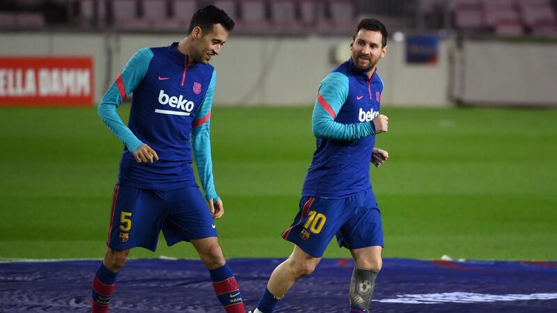 Barcelona's Argentinian forward Lionel Messi (R) and Barcelona's Spanish midfielder Sergio Busquets warm up before the Spanish League football match between FC Barcelona and Deportivo Alaves at the Camp Nou stadium in Barcelona on February 13, 2021. (Photo by LLUIS GENE / AFP)