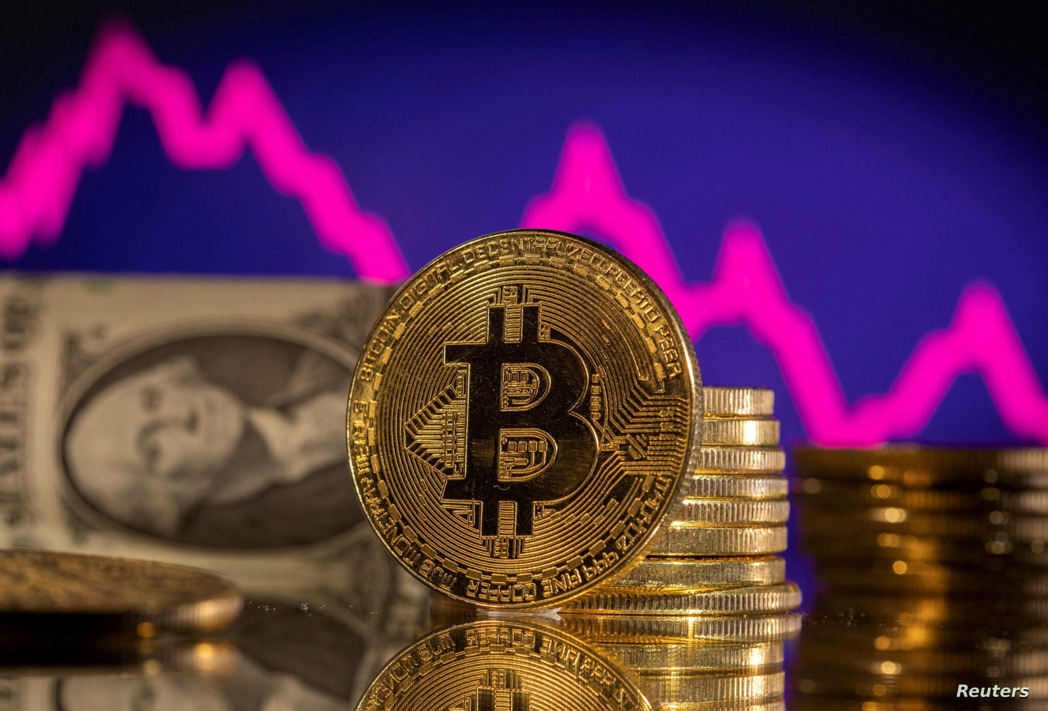 FILE PHOTO: Illustration shows representations of cryptocurrency Bitcoin FILE PHOTO: A representations of cryptocurrency Bitcoin is seen in front of a stock graph and U.S. dollar in this illustration taken, January 24, 2022. REUTERS/Dado Ruvic/Illustration/File Photo