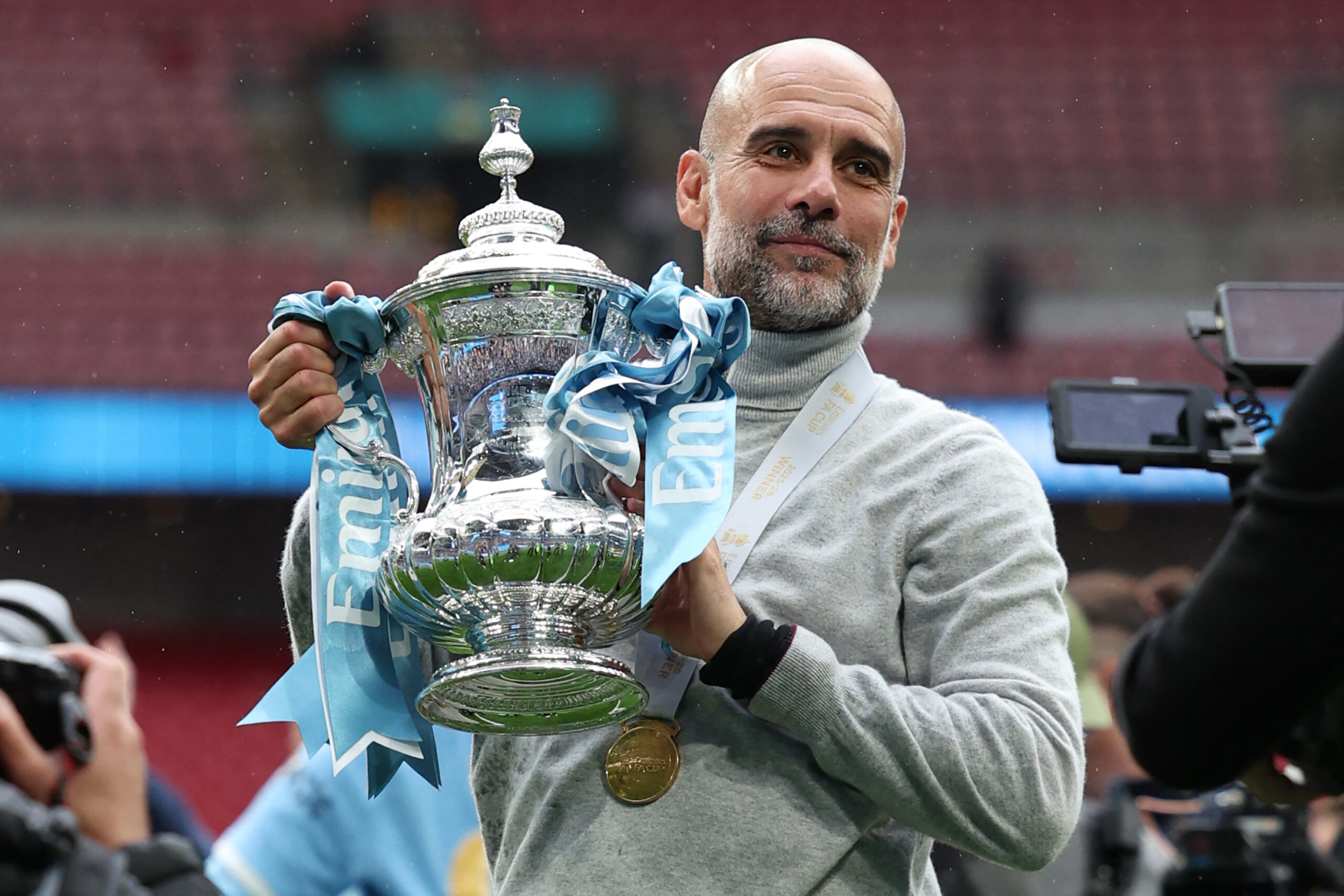 TOPSHOT - Manchester City's Spanish manager Pep Guardiola poses with the trophy on the pitch after the English FA Cup final football match between Chelsea and Manchester City at Wembley stadium in London, on May 16, 2026. Manchester City won the game 1-0. The third FA Cup success of Guardiola's reign ended City's run of two successive defeats in the final. (Photo by Adrian Dennis / AFP via Getty Images) / NOT FOR MARKETING OR ADVERTISING USE / RESTRICTED TO EDITORIAL USE